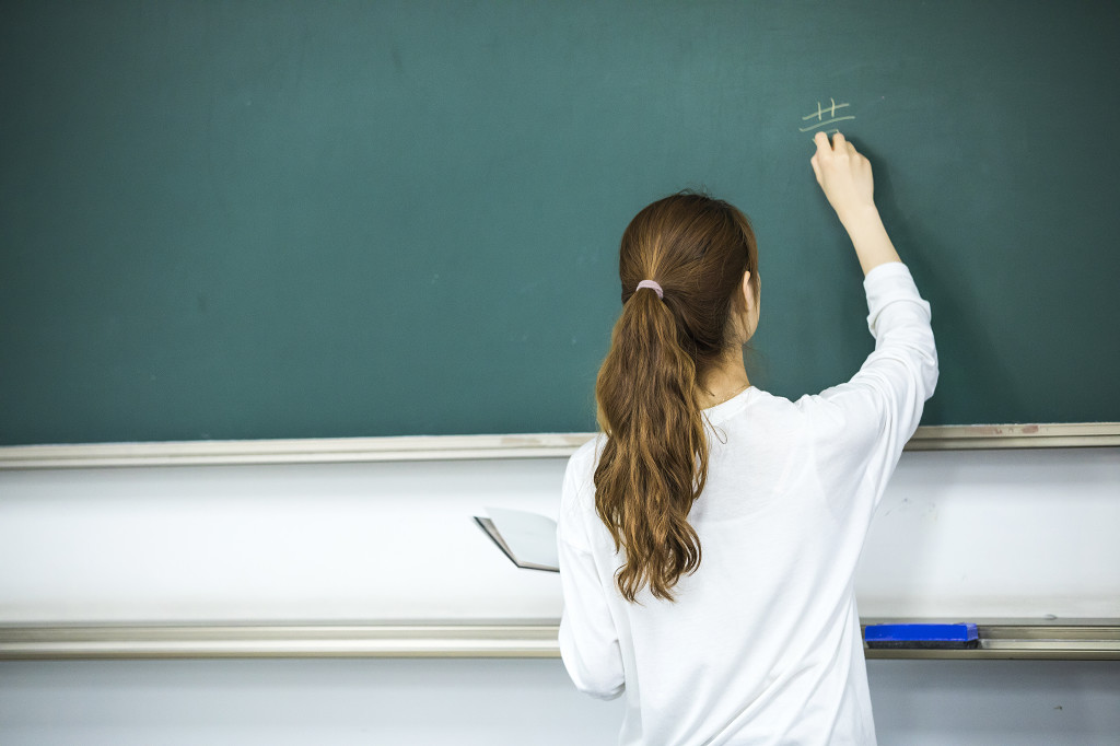 校园毕业季学生在黑板上写字