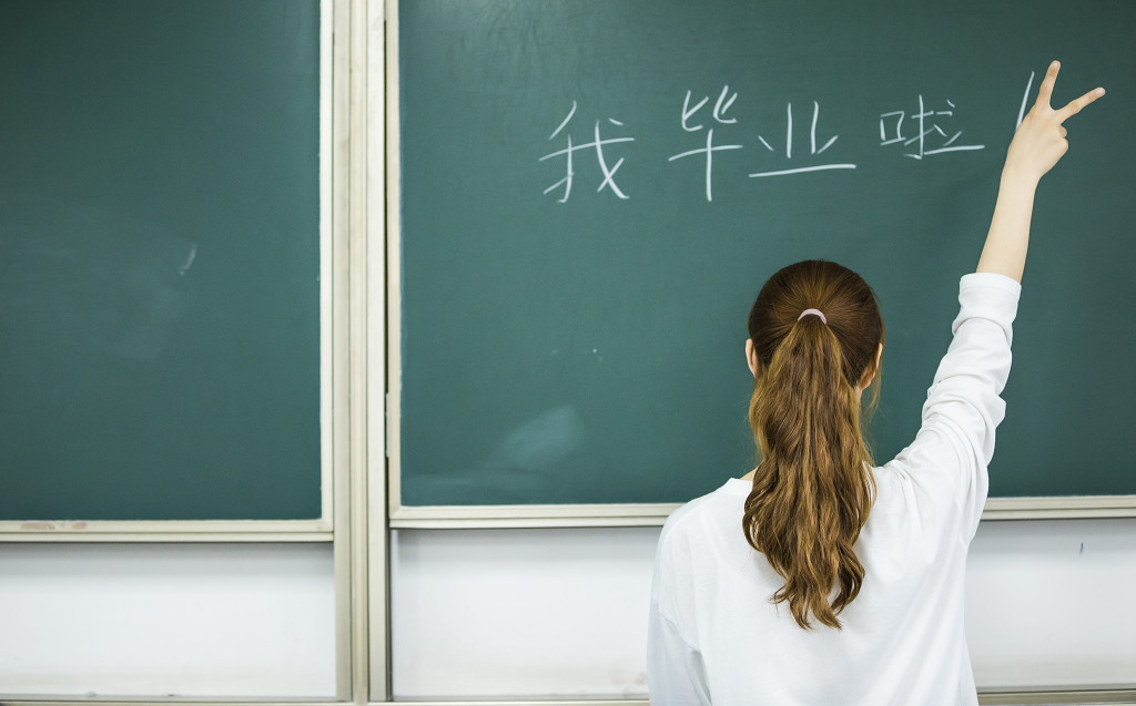 校园毕业季学生在黑板上写字