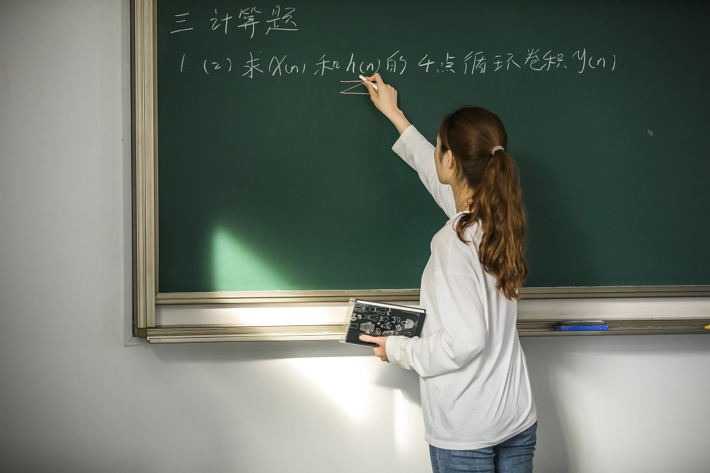 校园毕业季学生在黑板上写字