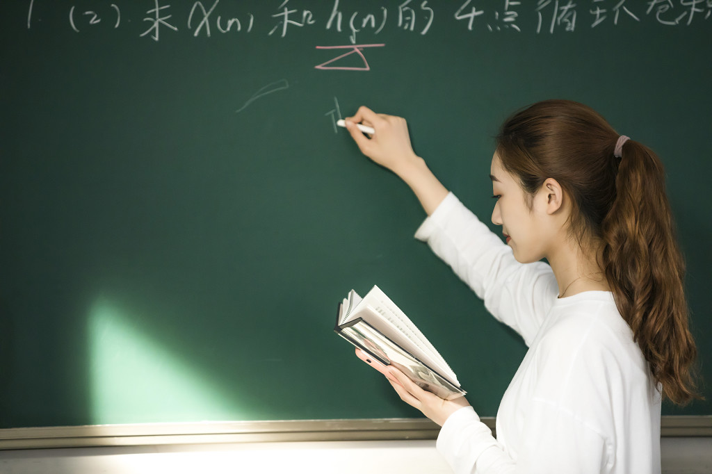 校园毕业季学生在黑板上写字