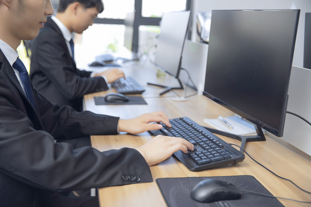 商务人士电脑前打字认真工作图片