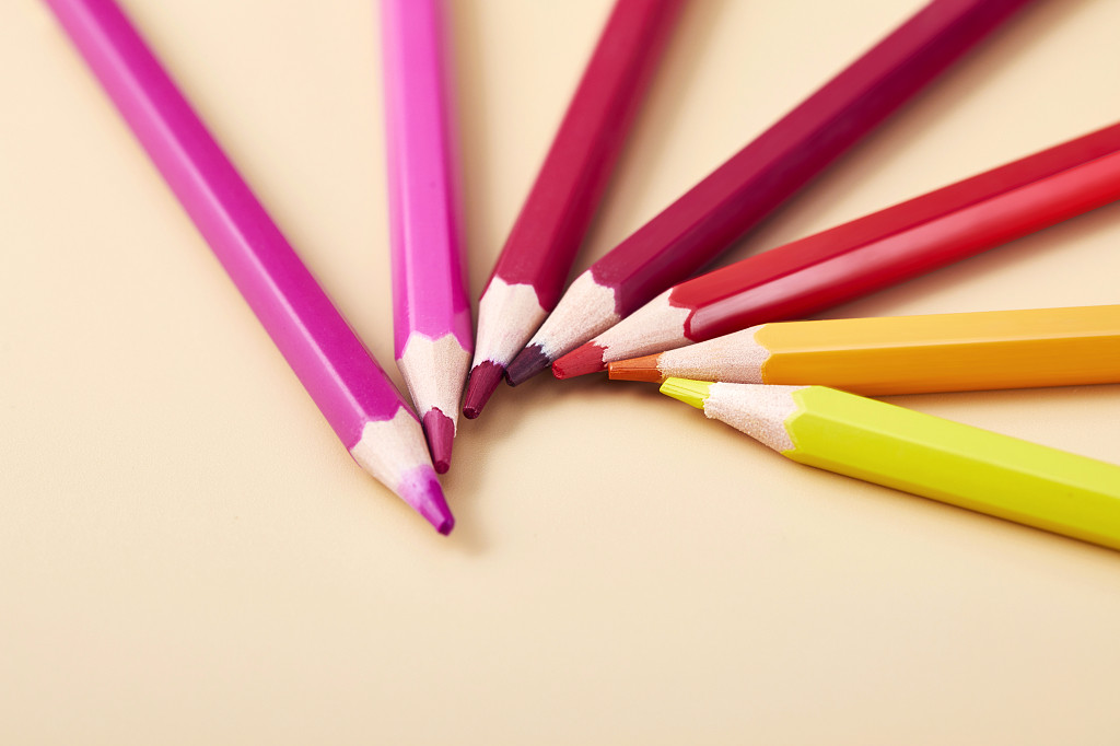 开学季纯色背景纸上的放射状彩色铅笔场景配图