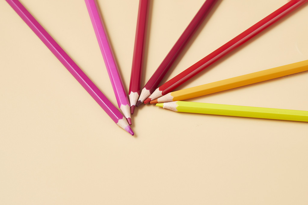 开学季纯色背景纸上的放射状彩色铅笔文具场景配图创意图