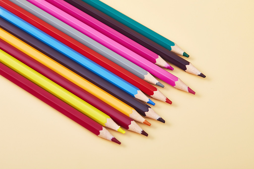 开学季一堆并排彩色铅笔在纯色背景纸上的场景配图创意图