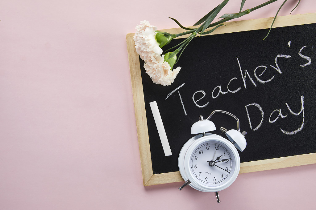 鲜花花朵教师节纯色背景上的小黑板闹钟康乃馨花朵场景素材配图俯视图