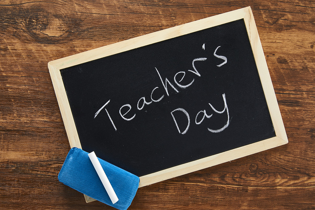 鲜花花朵教师节木桌上的小黑板黑板擦粉笔场景素材配图俯视图