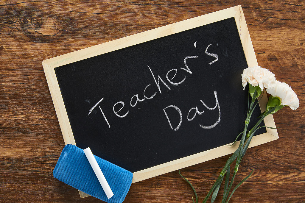 鲜花花朵教师节木桌上的小黑板康乃馨黑板擦粉笔场景素材配图俯视图