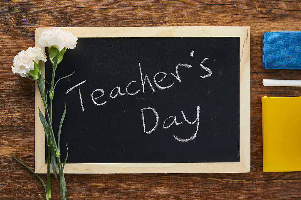 鲜花花朵教师节木桌上的小黑板康乃馨黑板擦笔记本场景素材配图俯视图