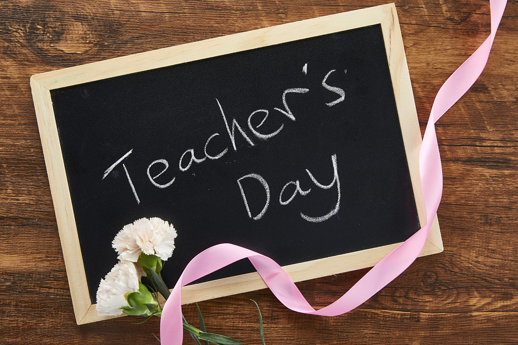 鲜花花朵教师节木桌上被丝带缠绕的小黑板康乃馨场景素材配图俯视图