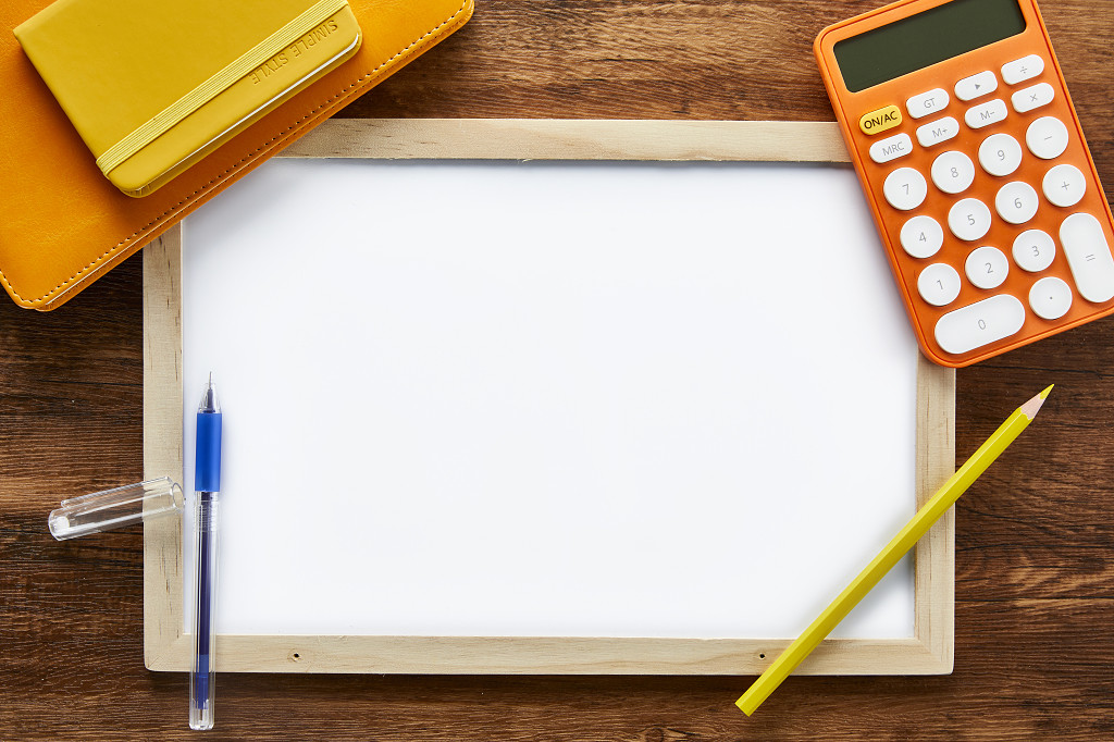 教师节木桌上的白板笔记本计算器笔文具学习用品场景素材俯视图