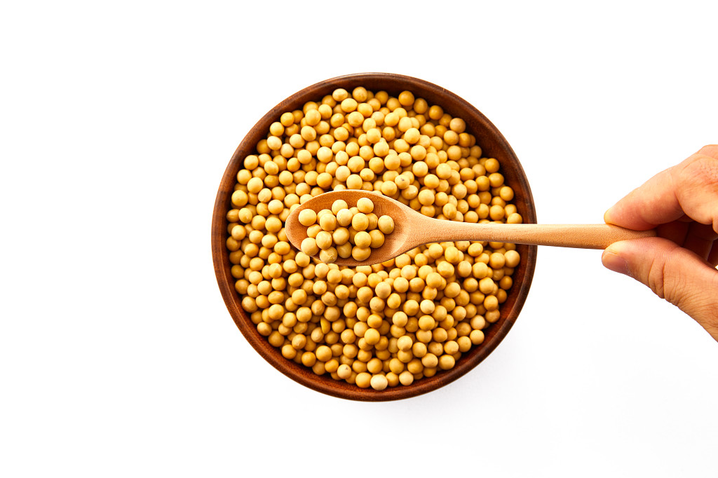 粮食白底木碗木勺手拿一勺黄豆大豆配图谷物