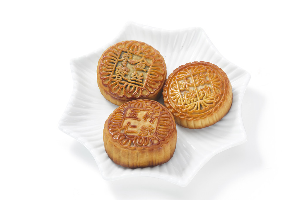 中秋月饼中秋元素中秋佳节迎中秋浓情中秋不同口味的金色月饼摆放在盘子里白底图中秋中秋节