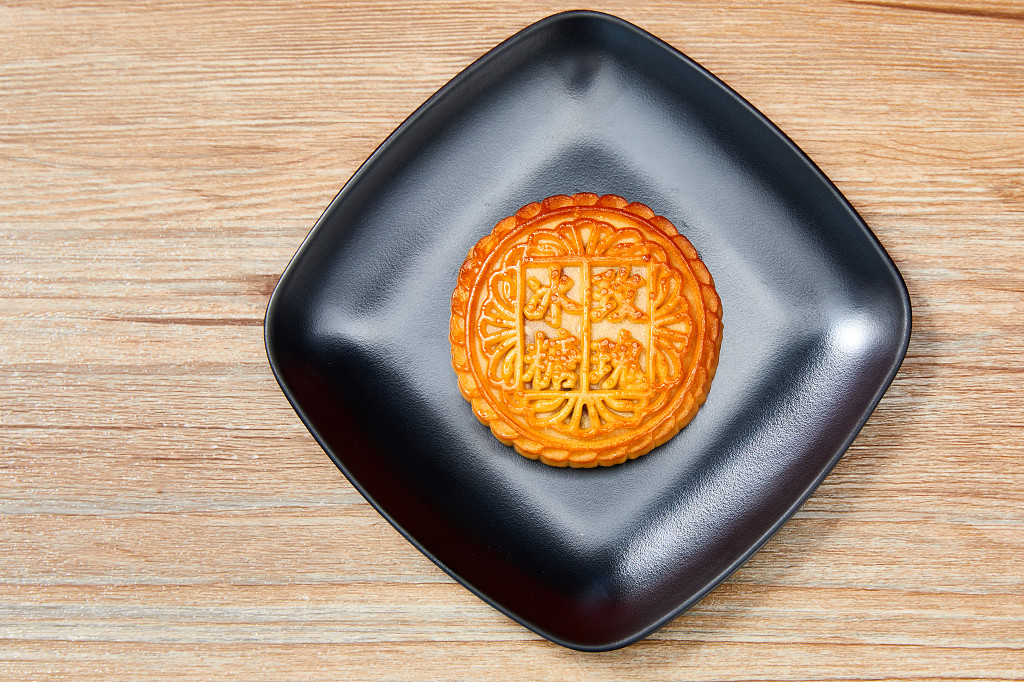 中秋月饼中秋中秋佳节迎中秋浓情中秋木纹实拍黑盘子月饼一块月饼冰糖玫瑰中秋节配图