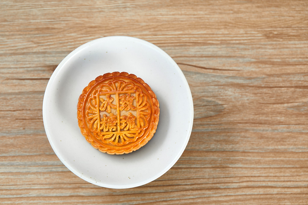 中秋月饼中秋中秋佳节迎中秋浓情中秋木纹实拍白碗月饼一块月饼冰糖玫瑰中秋节配图