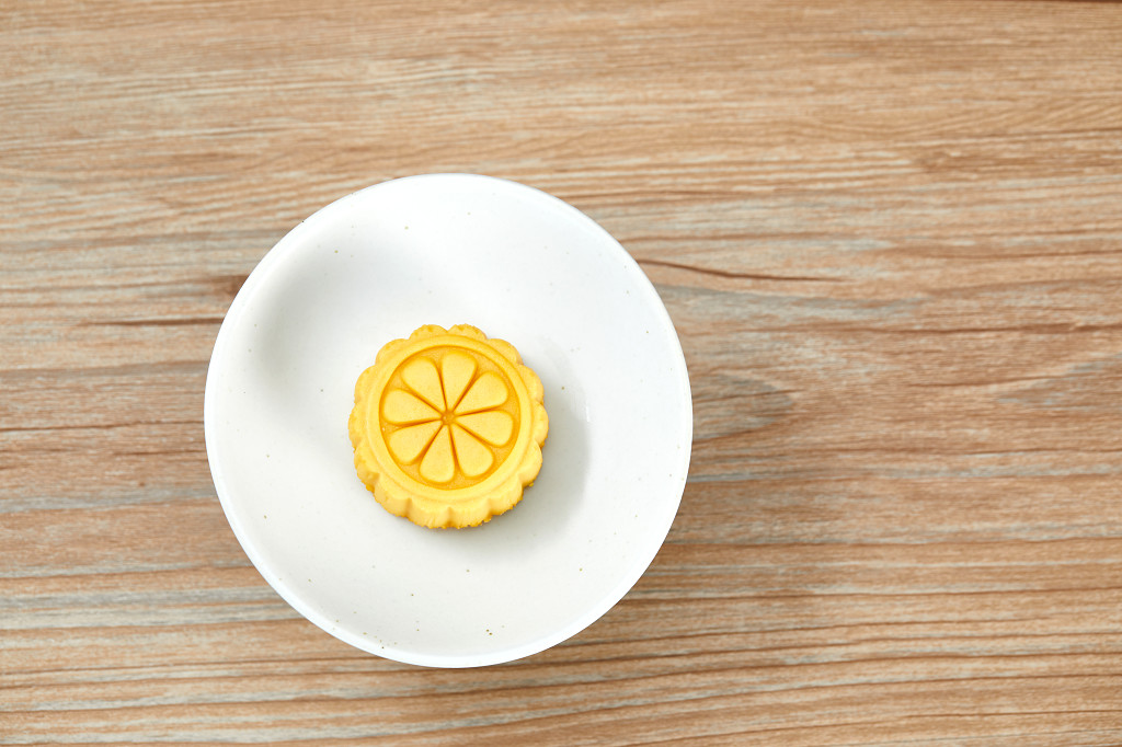 中秋月饼中秋中秋佳节迎中秋浓情中秋木纹实拍白碗月饼一块月饼彩色月饼中秋节配图