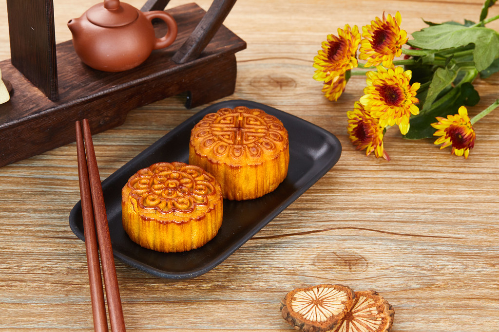 中秋背景中秋月饼中秋中秋佳节迎中秋浓情中秋木纹实拍黑碗筷子花朵茶壶月饼三块月饼中秋节