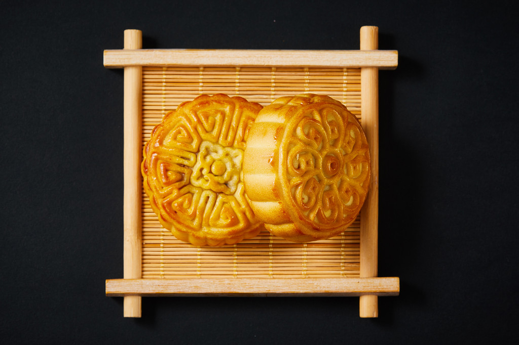 浓情中秋中秋佳节中秋png中秋元素中秋月饼黑底实拍木盘木托月饼两块月饼中秋节配图