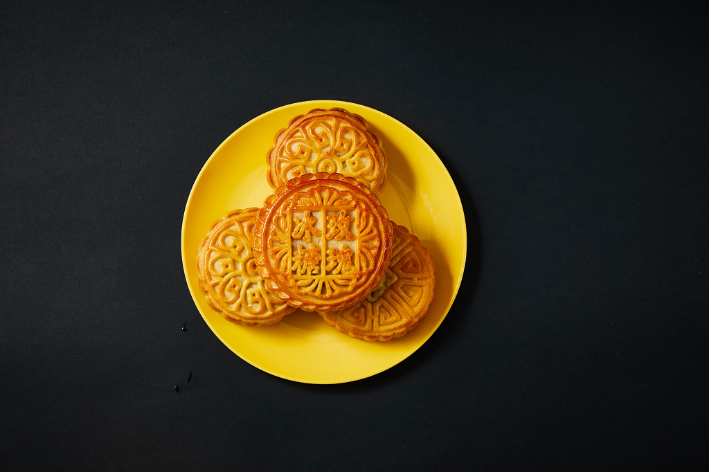 中秋月饼中秋中秋佳节迎中秋浓情中秋黑底实拍盘子瓷盘月饼四块月饼冰糖玫瑰中秋节配图