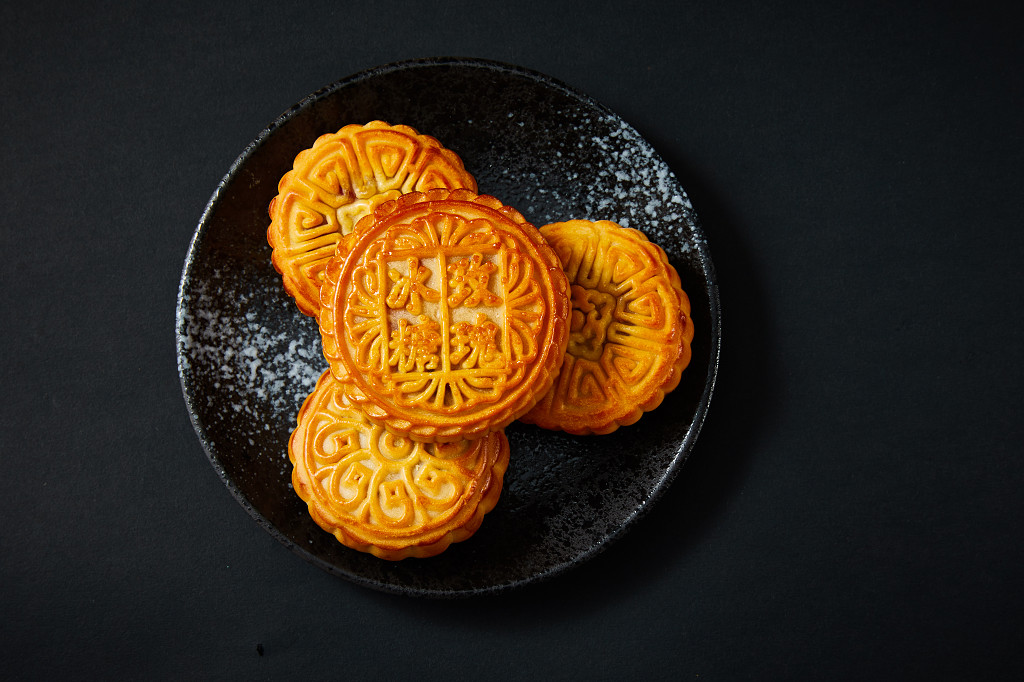 中秋月饼中秋中秋佳节迎中秋浓情中秋黑底实拍盘子瓷盘月饼四块月饼冰糖玫瑰中秋节配图