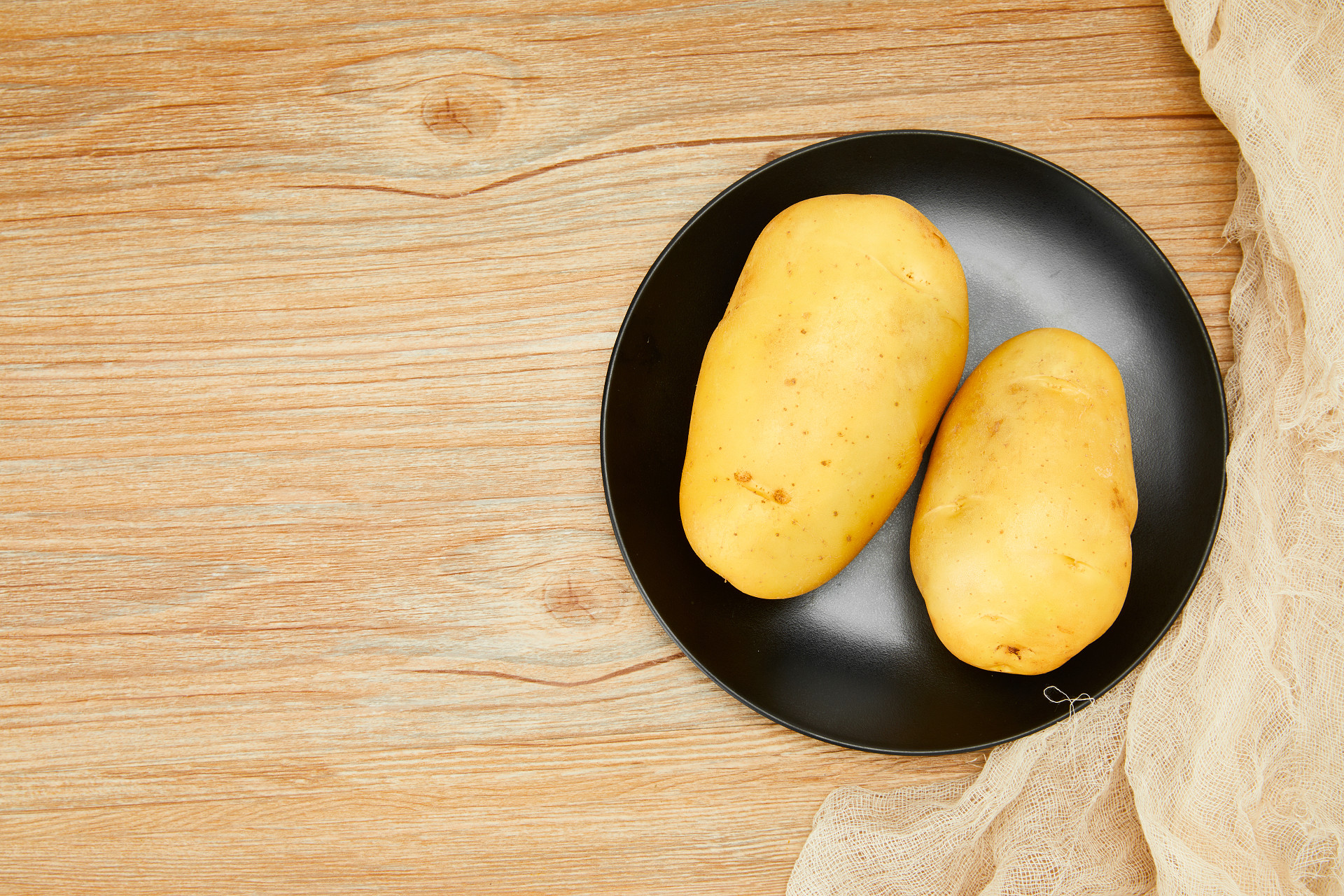 木纹黑盘盘子蔬菜两个土豆新鲜蔬菜土豆马铃薯