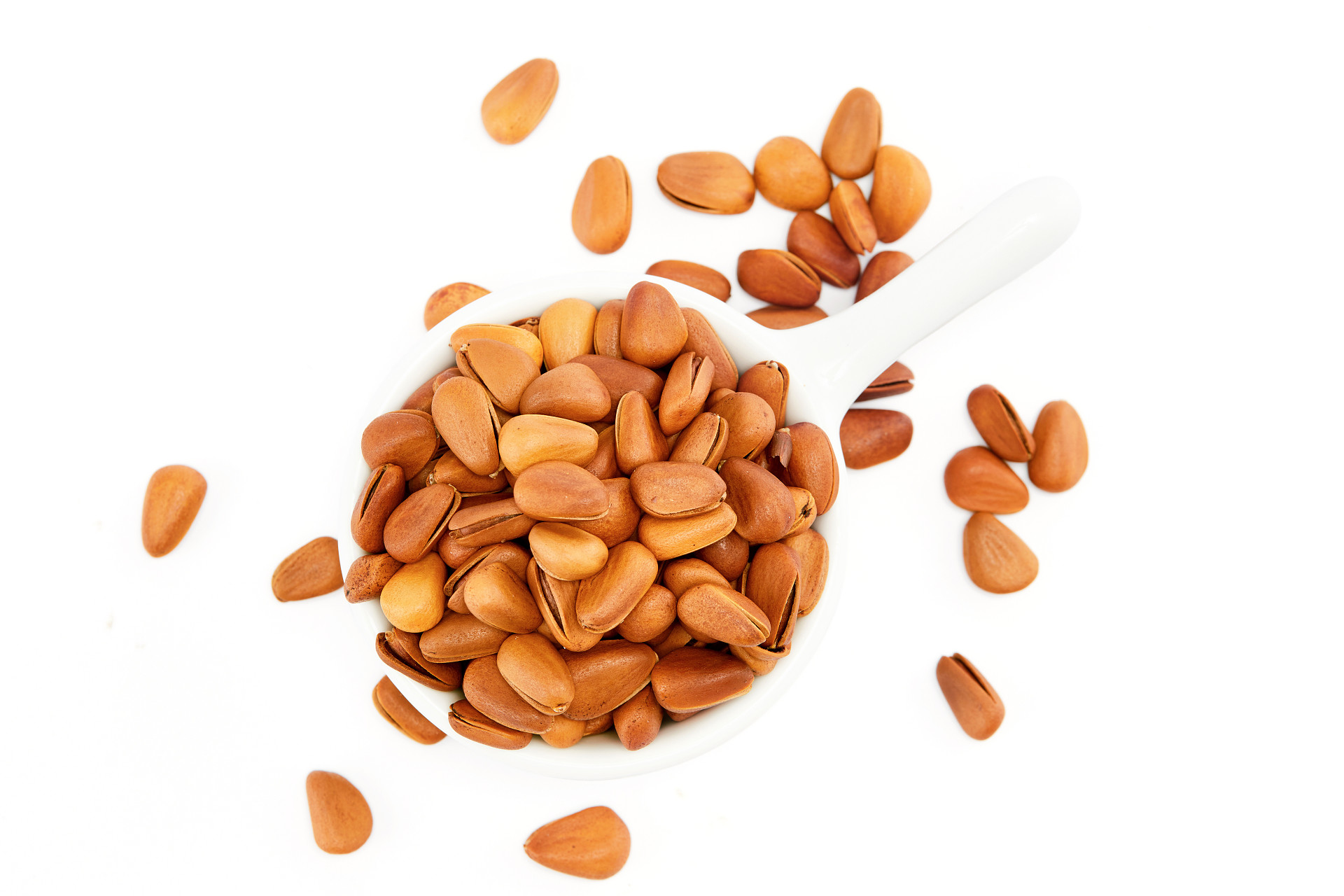 俯视图白底白碗一碗松子散落松子坚果松子开口松子