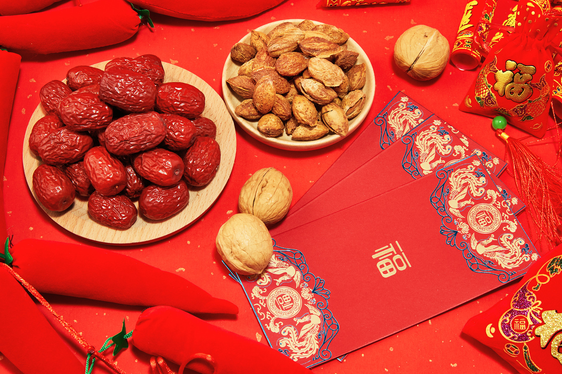 俯视图红色纹理纸坚果一盘红枣一盘巴旦木红包新年元素