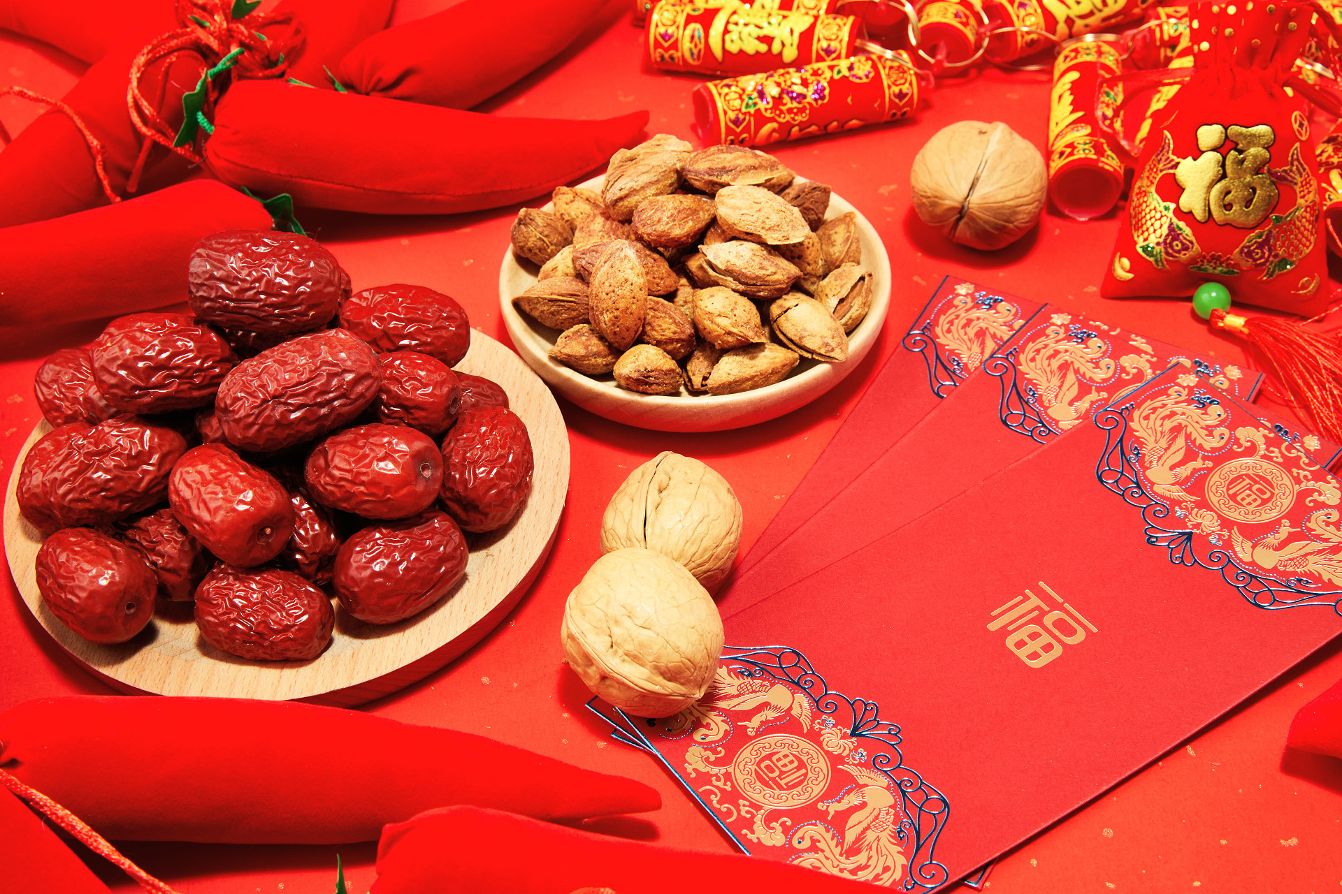 红色纹理纸坚果一盘红枣一盘巴旦木散落坚果红包新年元素