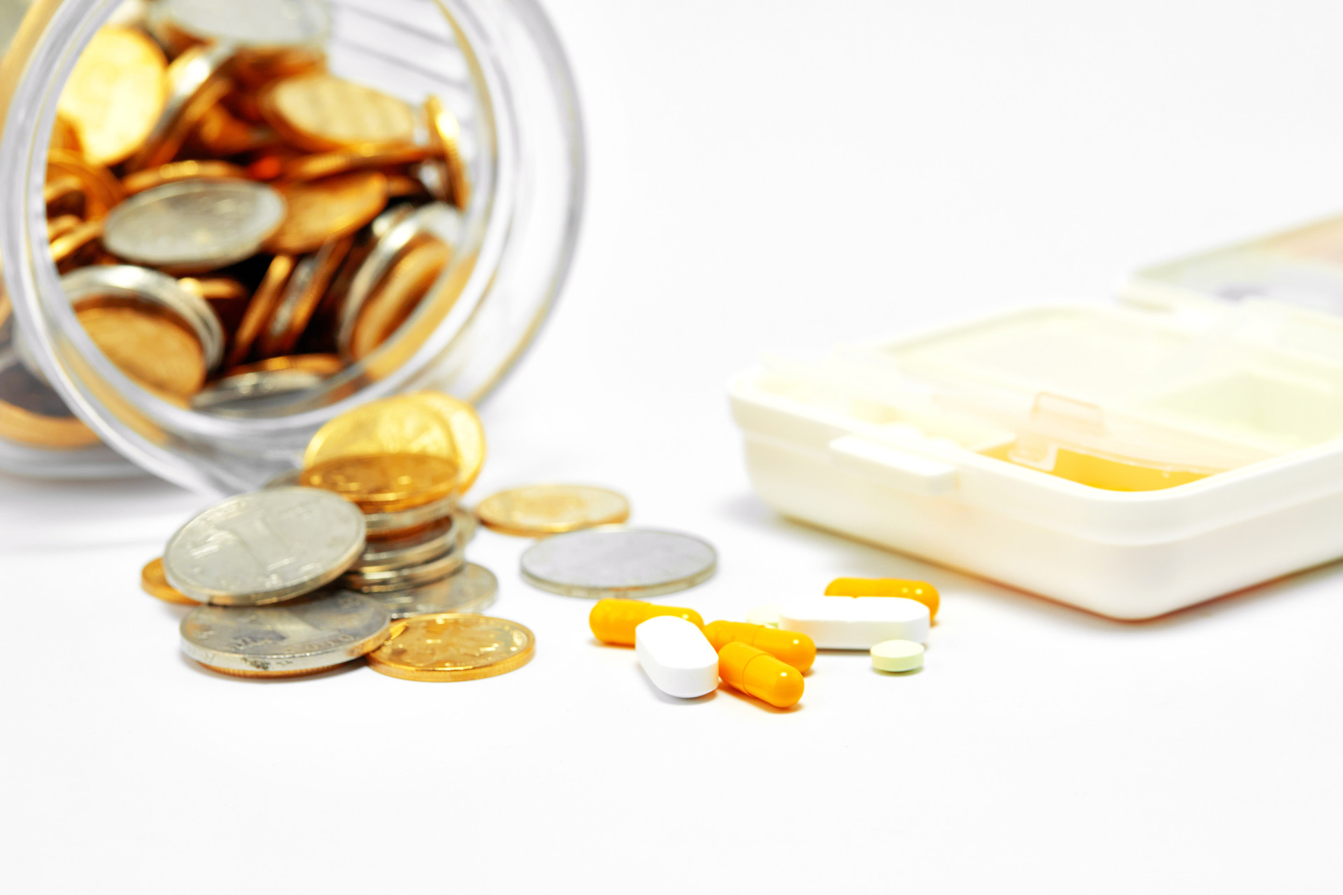 灰底散落硬币存钱罐散落药片药品胶囊药片