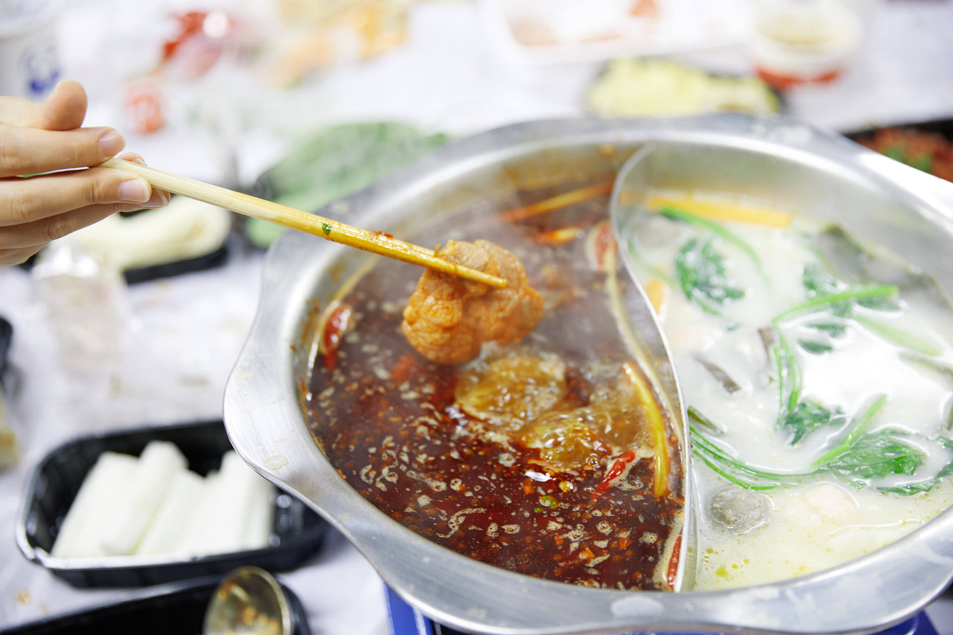 手拿筷子火锅鸳鸯锅清汤麻辣涮火锅美食美味聚餐