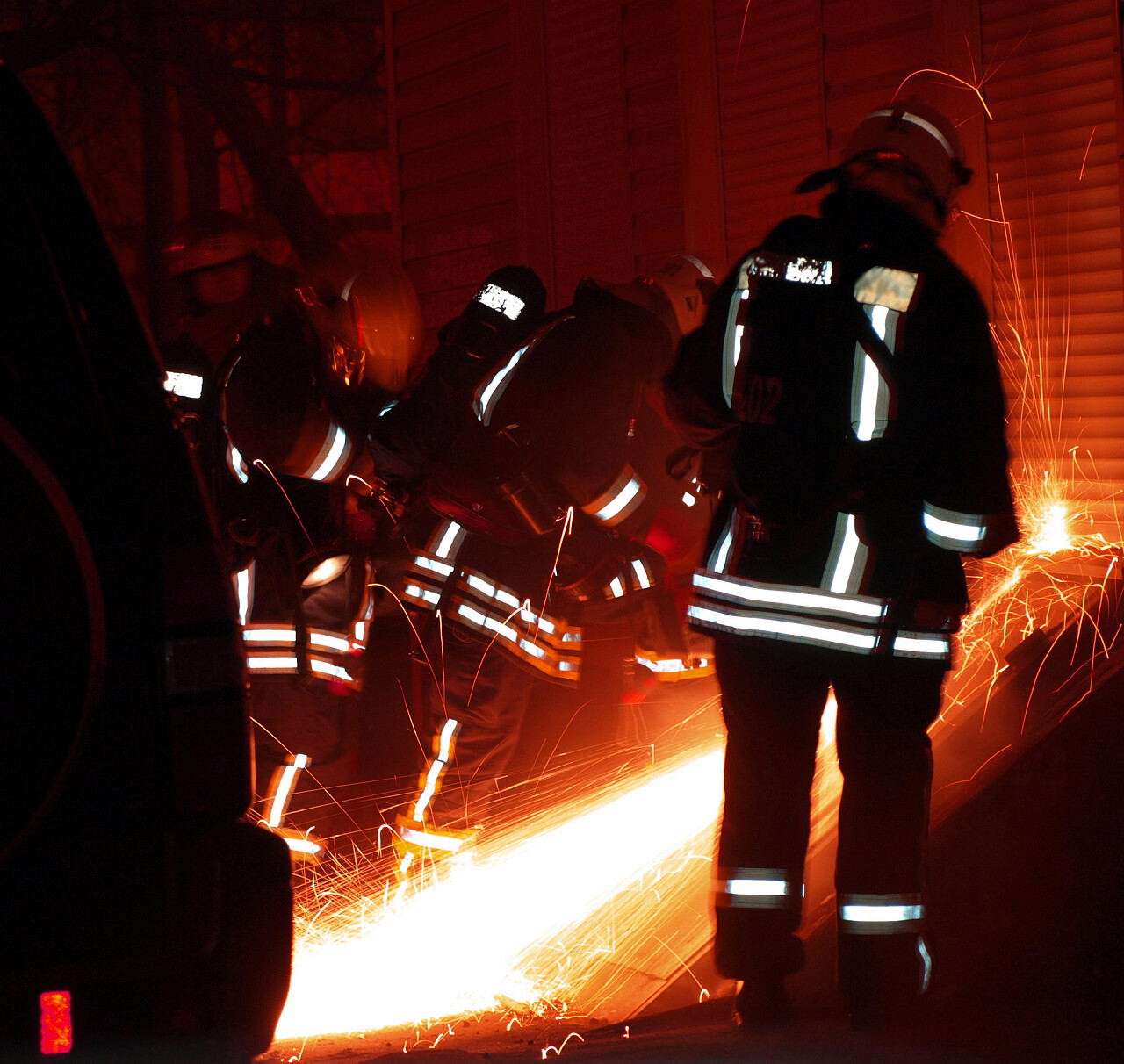 夜晚消防员切割卷帘门救援任务人物图片