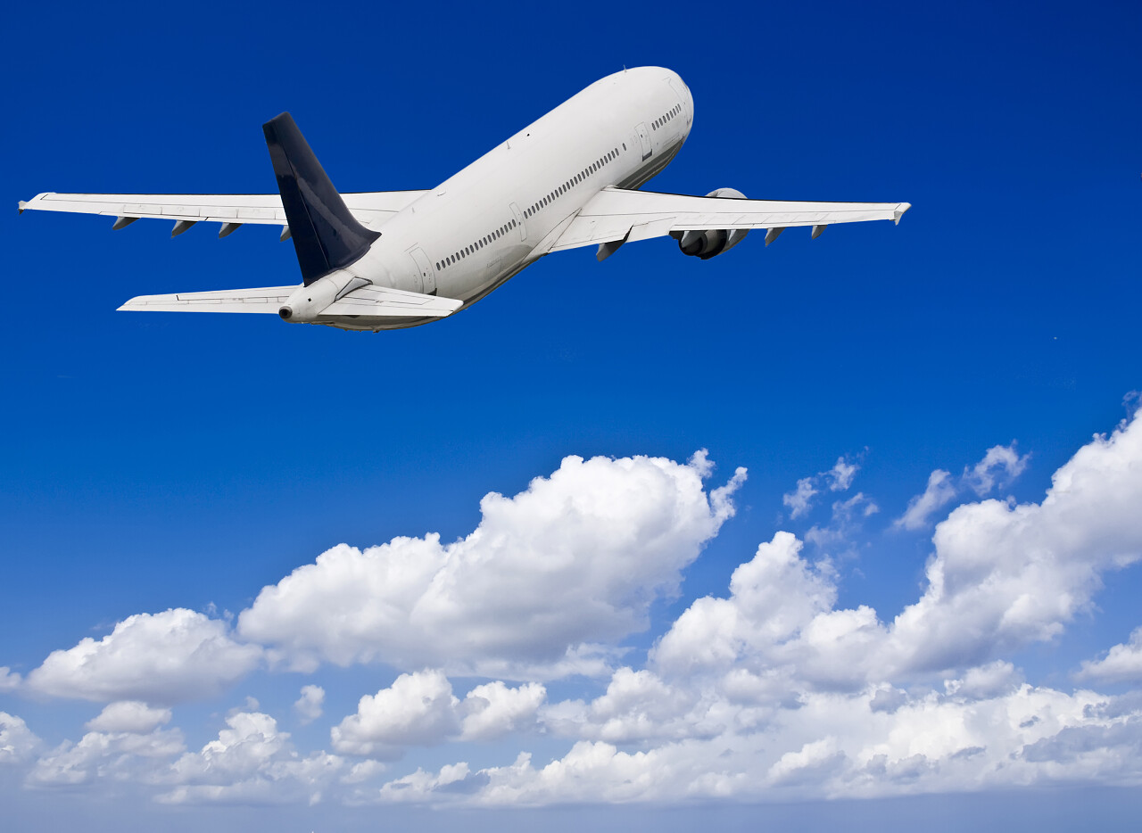 蓝天白云背景下飞翔蓝天的白色客机飞机