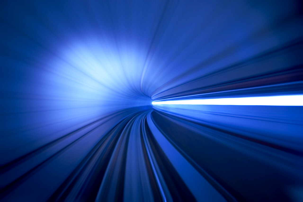 蓝色渐变列车在隧道中高速行驶转弯模糊背景图