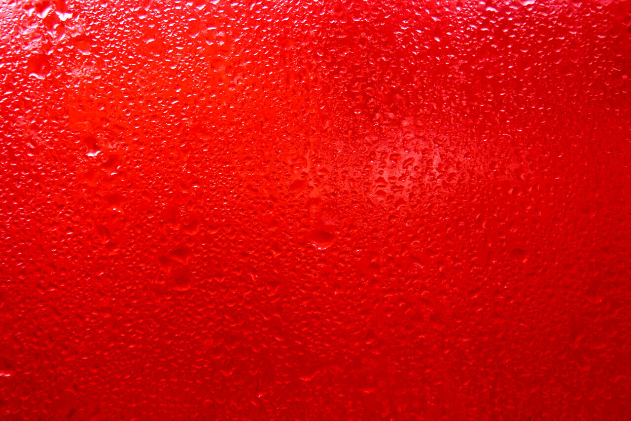 红色玻璃玻璃上的水滴雨打的窗户