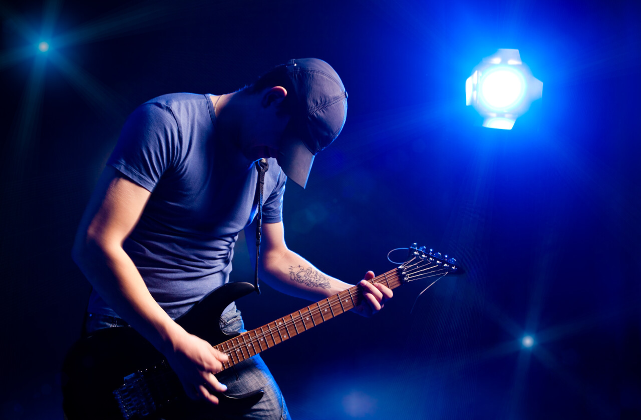 蓝色背景歌手电吉他吉他手演唱会照片射灯灯光