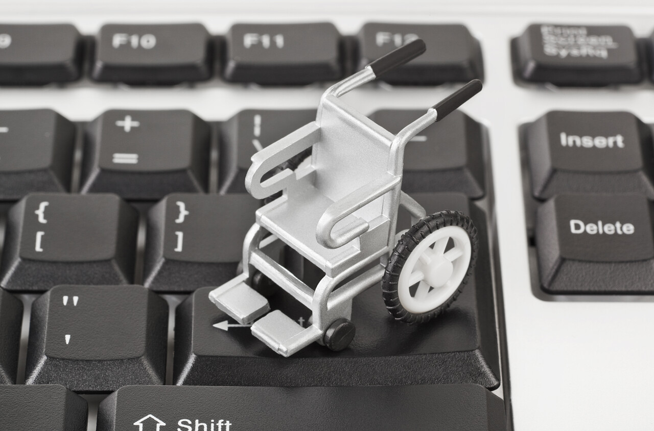 商务灰白计算机键盘背景上的轮椅