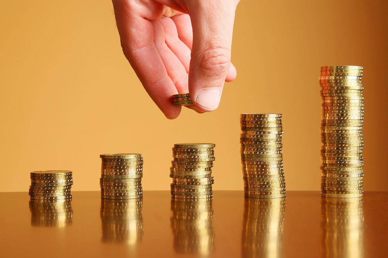一只手在做硬币上财富上升表收入提升