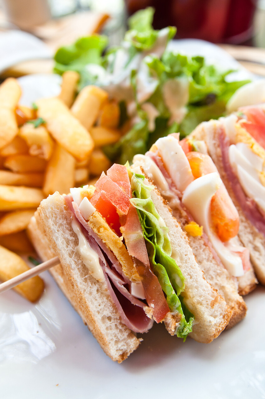 白底一串夹杂着培根鸡肉奶酪蔬菜的三明治