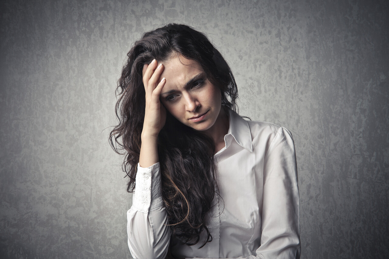 患头痛的捂着头的年轻女人焦虑后悔