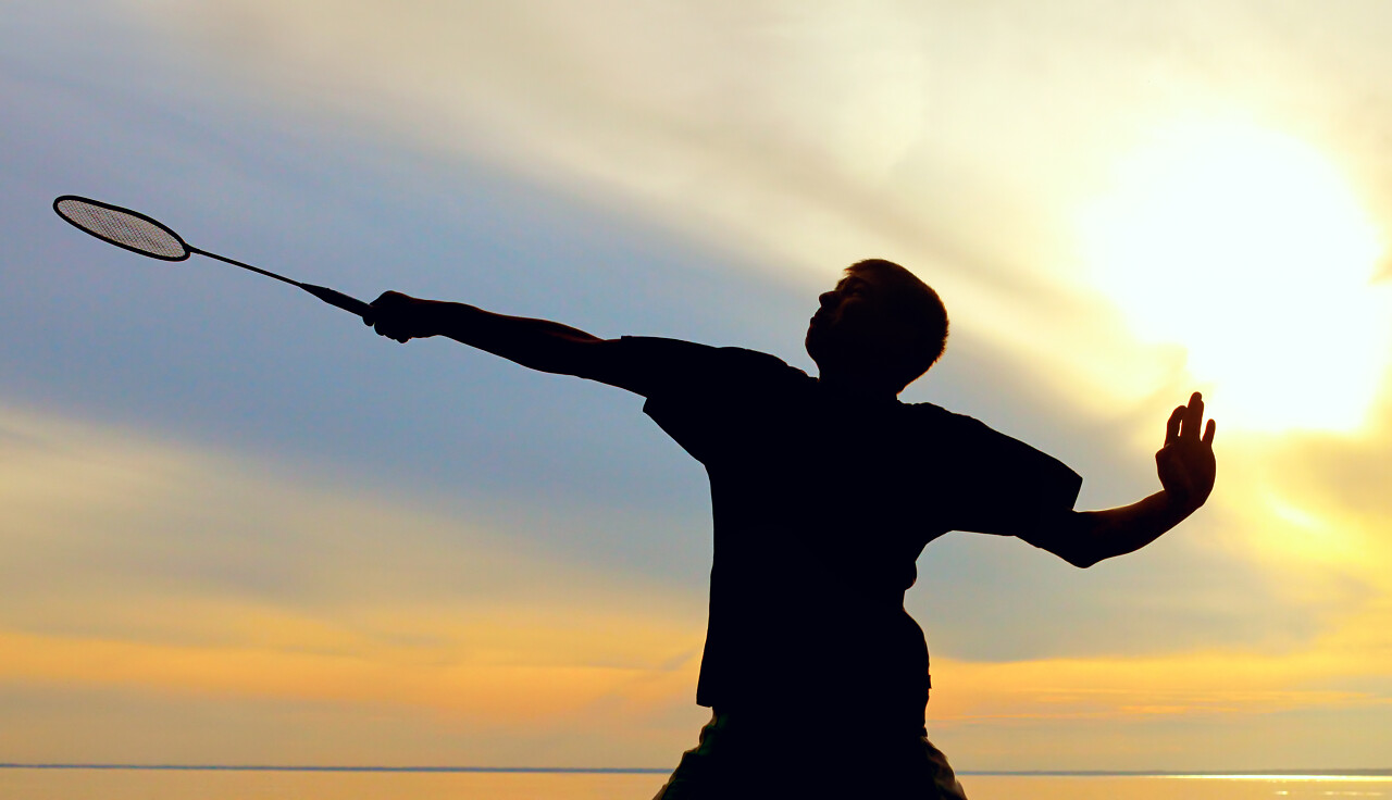 羽毛球球员在傍晚的天空的轮廓