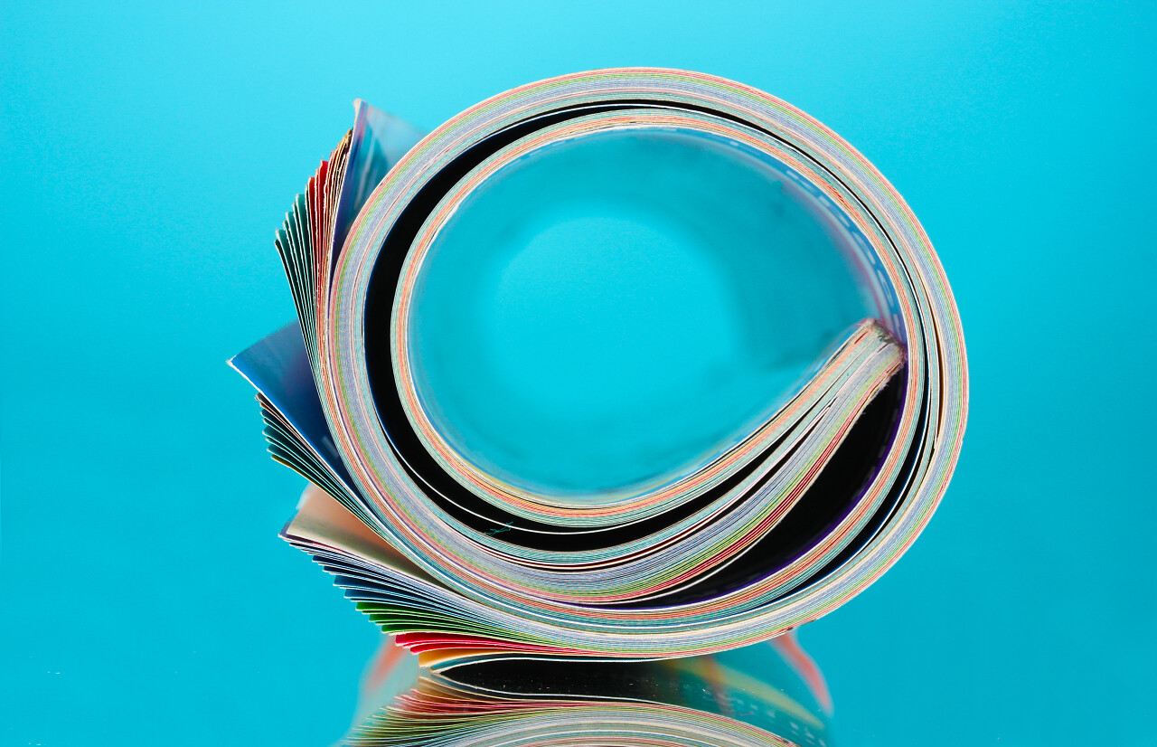 创意在蓝色背景上卷起杂志