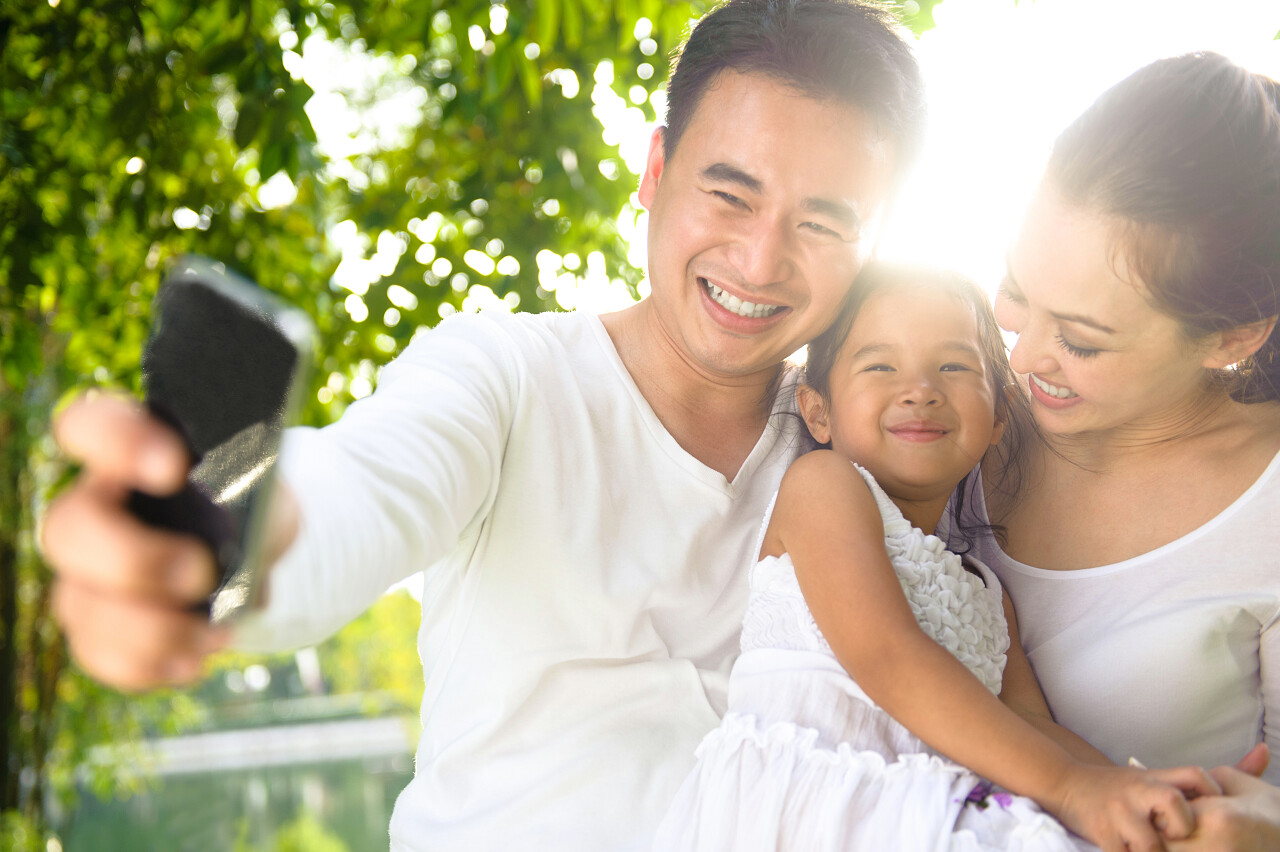 在公园拍照的亚洲家庭幸福一家三口