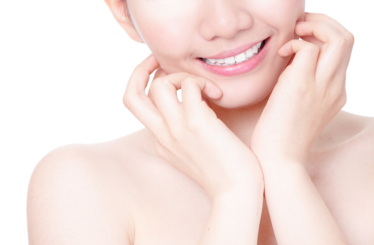 女孩嘴紧嘴角挂着甜美的微笑手指头触摸着苍白的背景模特儿是一位亚裔美女