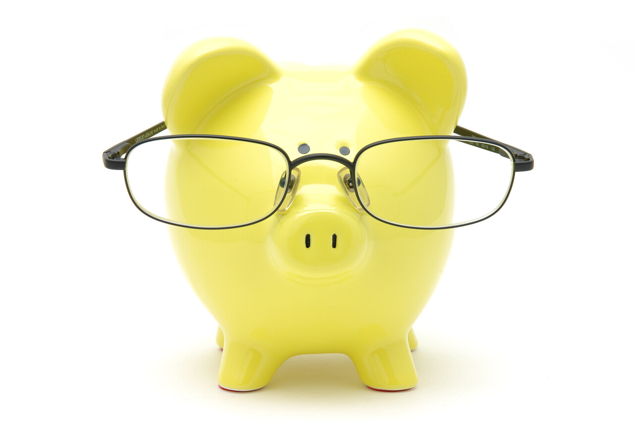 戴着眼镜在孤立的白色背景中的黄色存钱罐