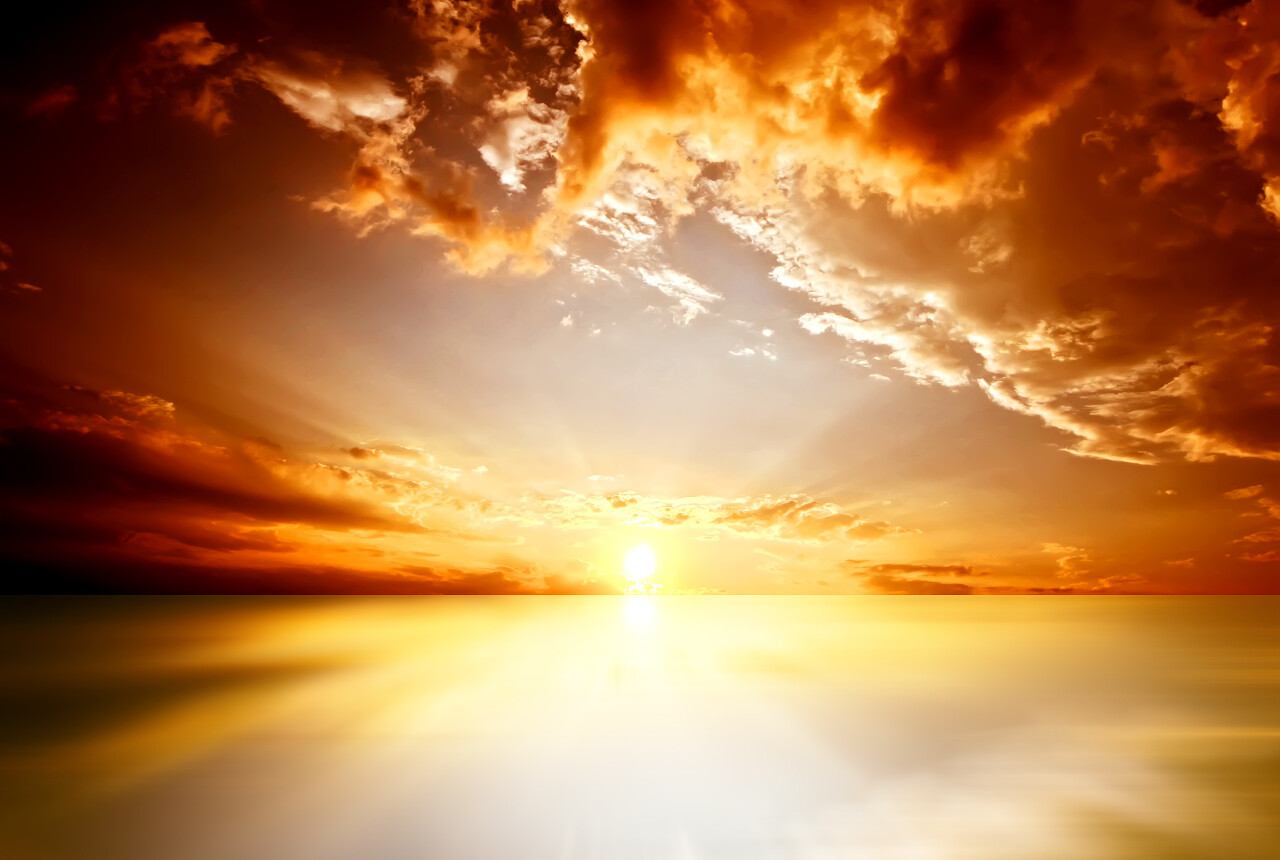 海面上的红色落日乌云密布光芒斑斓