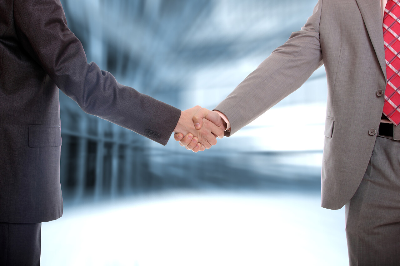 办公室达成这笔交易中的两个商业男子握手合作