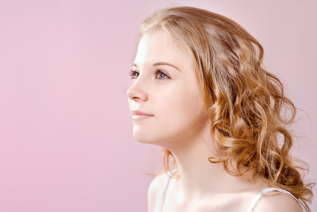 粉色背景美丽青春活泼的金发侧脸女孩鼻子整形美女三七女生节37女生节