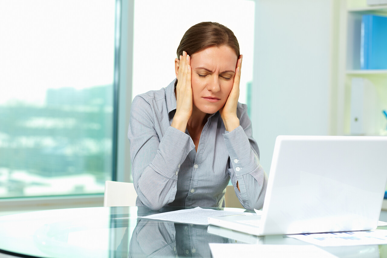 办公室笔记本旁工作烦躁愁苦头痛的女人双手按头头痛特写人物疲劳辛苦工作焦虑疲劳烦躁困扰图片