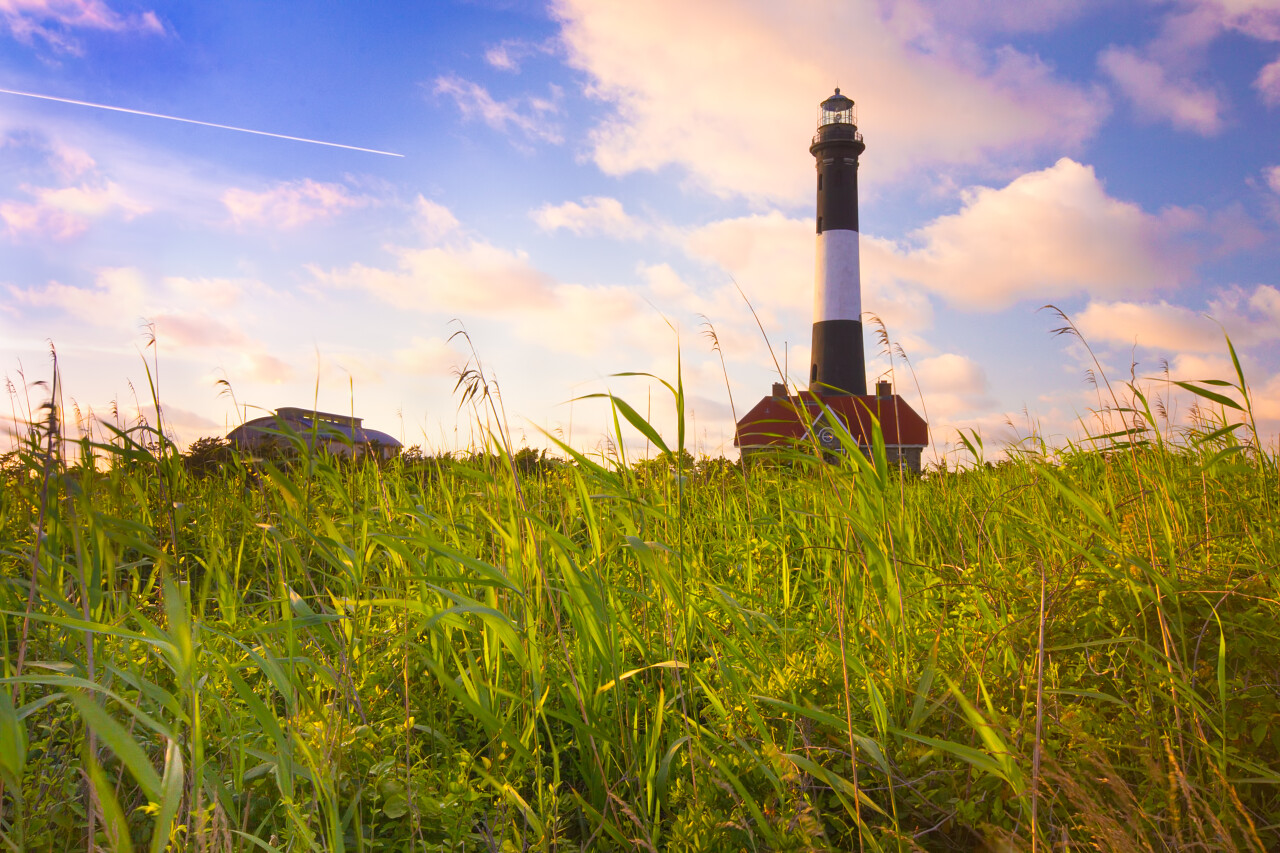 蓝天白云下青草原上矗立的灯塔