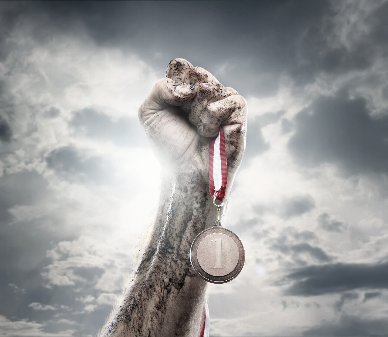 在戏剧性的天空拿金牌的男性手奋斗拳头加油拳头胜利