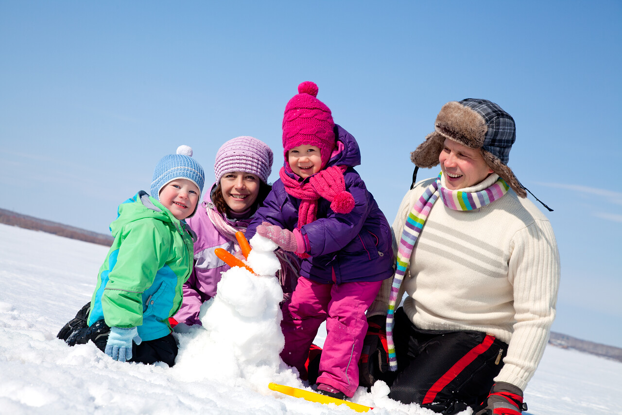 幸福的夫妻有两个孩子使大堆雪人